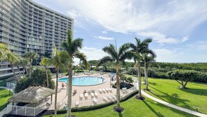 A hotel with a large pool surrounded by palm trees and lounge chairs. - South Seas T4- 306: Beautiful end unit condo, Beach Front (Marco Island)