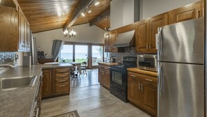 Una cocina amplia con armarios de madera, un refrigerador de acero inoxidable y una isla grande.
