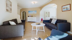 A modern living room with two sofas, a coffee table, and a white cabinet. - Top renovated townhouse with pool and sea access (Porches)