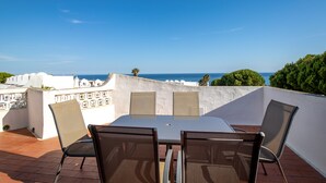 A terrace with a table and chairs, overlooking a coastal view. - Top renovated townhouse with pool and sea access (Porches)
