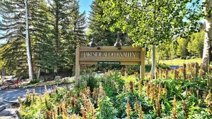 Señal de Lakeside en Deer Valley, con vistas a un jardín ajardinado y árboles.