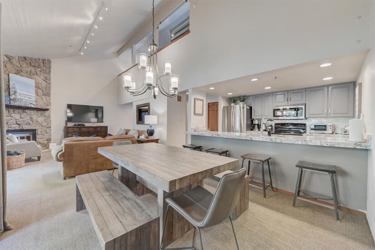 Et moderne køkken med en stor ø, indbyggede apparater og en væg med stenvæg.