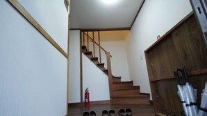 A staircase with wooden steps and a fire extinguisher on the landing.