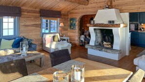 A cozy log cabin interior with a fireplace, wooden furniture, and a dining area. - 3 bedroom amazing home in Uvdal (Uvdal)