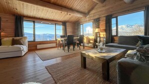 A cozy log cabin interior with a sofa, a coffee table, and a dining area. - 3 bedroom amazing home in Uvdal (Uvdal)