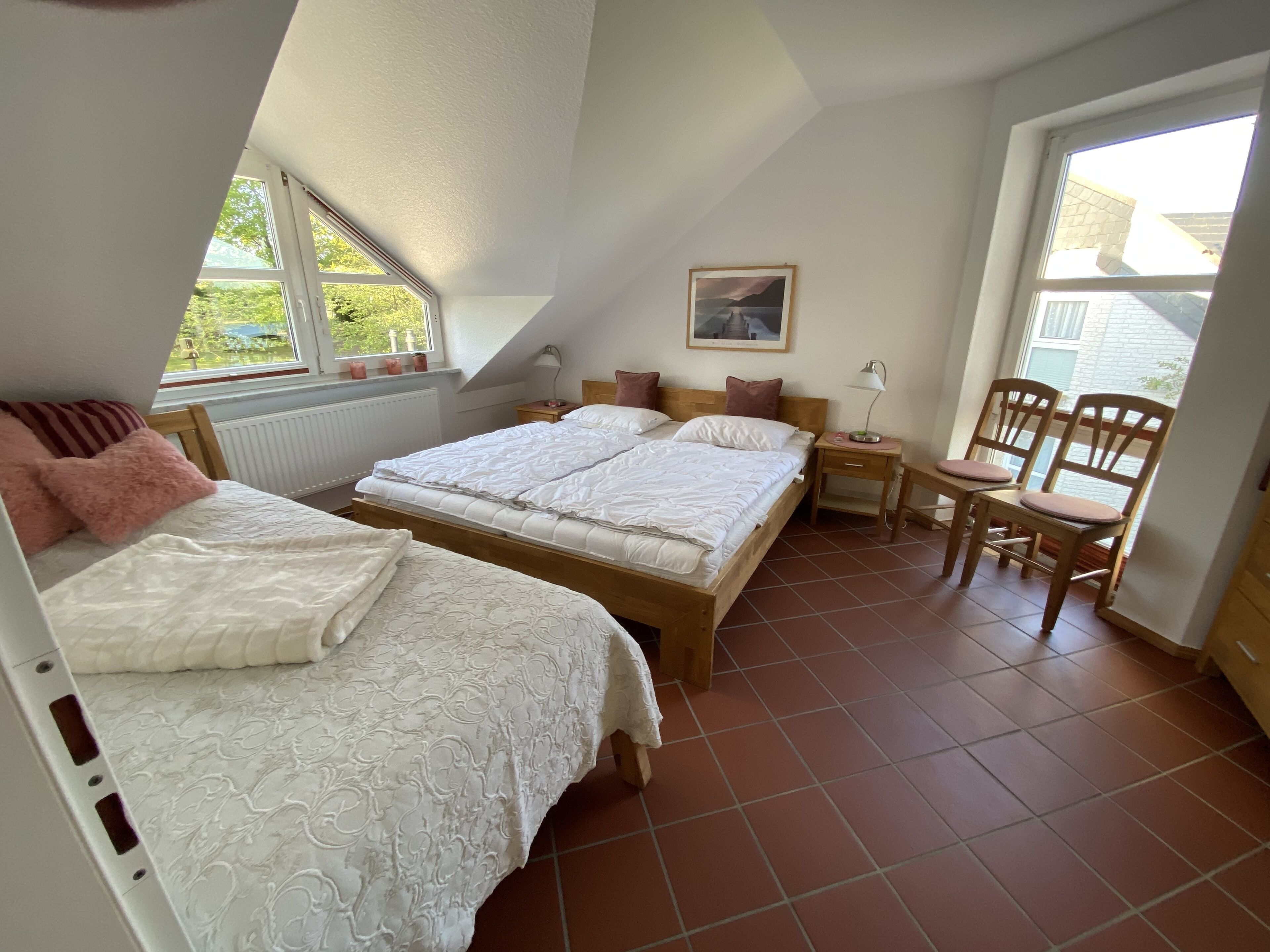 Een slaapkamer met twee bedden, een bureau en stoelen.