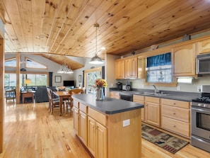 A wooden interior with a kitchen, dining area, and a large window. - September Special | Hot Tub+Breathtaking Mtn Views (Spruce Pine)