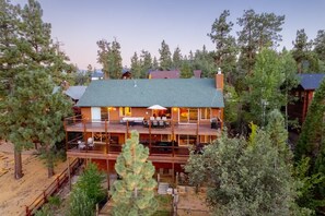 A multi-story lodge with outdoor seating and a covered patio.