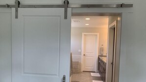 Un pasillo con una puerta corrediza que da a un baño.