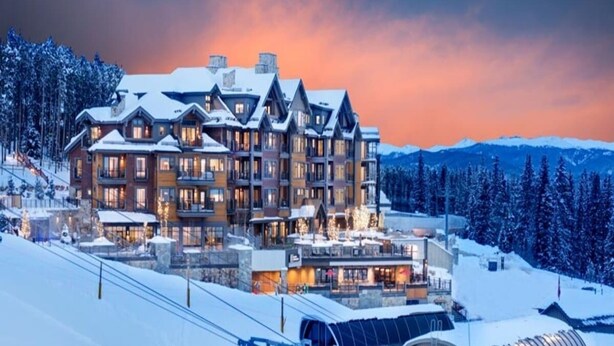 A large lodge with multiple floors and a ski lift in the foreground.