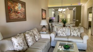 A living room with a sofa, a coffee table, and a painting on the wall. - Beautifully furnished Condo (Bradenton)
