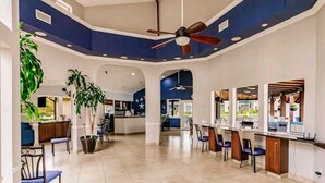 A spacious, modern kitchen with a central island, a dining area with chairs, and a bar area with stools. - Beautifully furnished Condo (Bradenton)