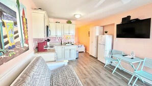 A compact living space with a kitchenette, a sofa, a dining table with chairs, and a ceiling fan. - 2nd Floor Beach Side Condo•Direct Beach Access•Pool•Pet-Friendly (Atlantic Beach)