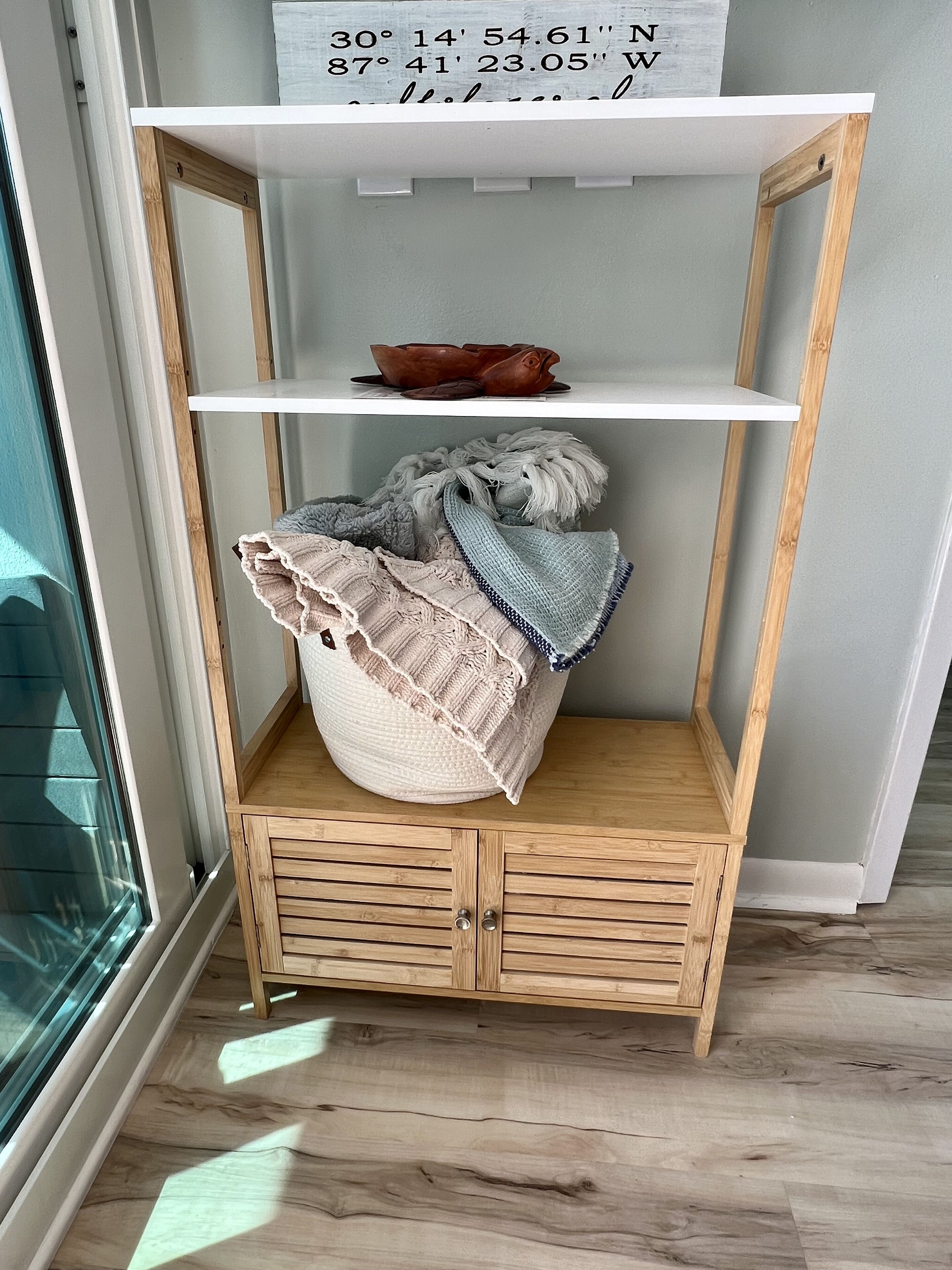 Ein Holzschrank mit weißem Regal, einem Unterschrank und einem Fenster links.
