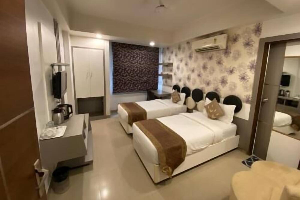 Habitació d'hotel amb dos llits, una escriptori, un armari i un bany.