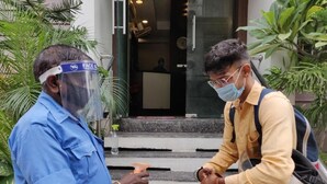 Two individuals interacting near a building entrance with steps and a reception desk visible inside. - Starlit Select Nirvana (Varanasi)