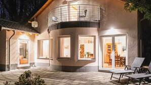 A two-story house with a balcony, large windows, and a patio area with outdoor furniture. - Amazing home in Nideggen with WiFi (Nideggen)