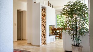 A modern interior with a wooden wall, a large potted plant, and a dining area with chairs and a table. - Amazing home in Nideggen with WiFi (Nideggen)
