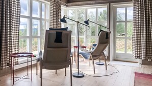 A room with large windows, two floor lamps, a small table, and two chairs. - Amazing home in Skåbu with sauna (Skåbu)