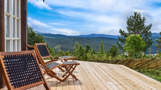 A wooden deck with outdoor furniture, overlooking a mountainous landscape. - Amazing home in Skåbu with sauna (Skåbu)