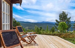 A wooden deck with outdoor furniture, overlooking a mountainous landscape. - Amazing home in Skåbu with sauna (Skåbu)