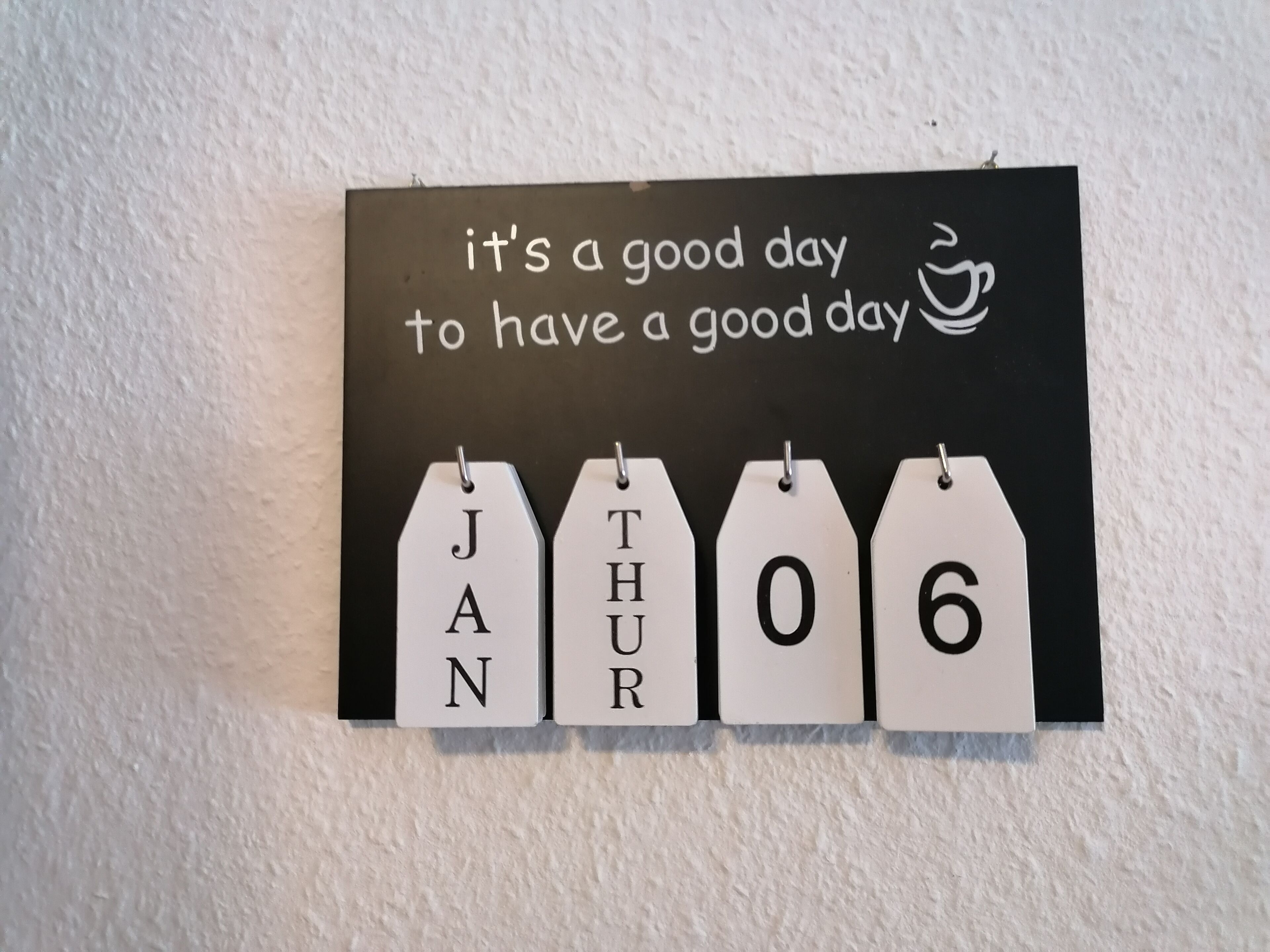 Uma placa na parede com uma mensagem motivacional e um calendário.