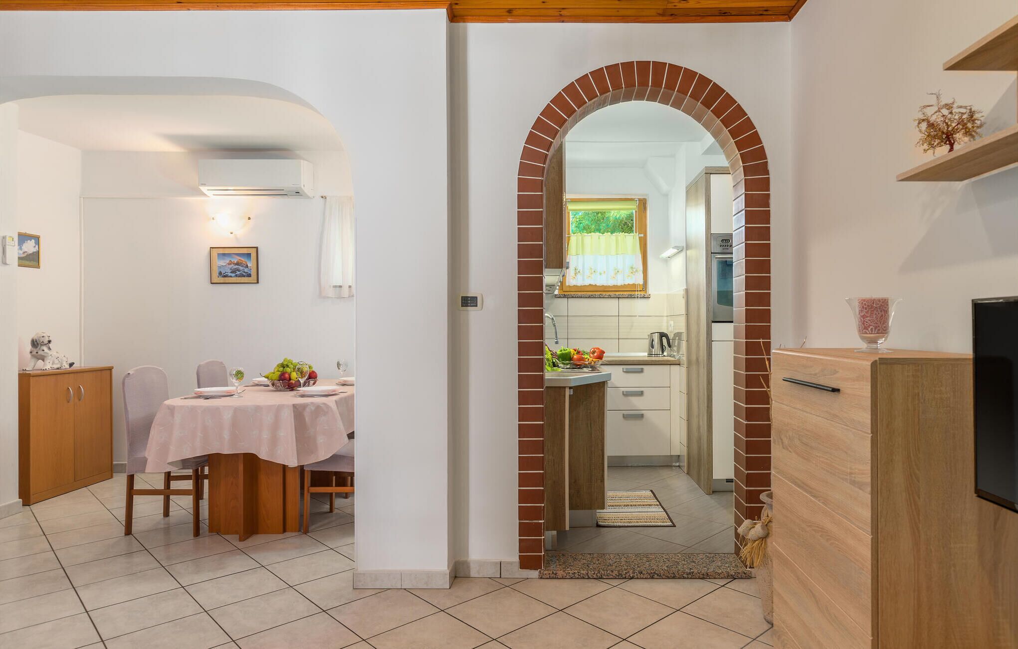 A compact kitchen with a brick archway leading to a dining area.