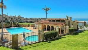A resort with a swimming pool, multiple buildings, and a view of the ocean. - 110 Pismo Shores: 2  BR, 1.5  BA Condominium in Pismo Beach, Sleeps 6 (Pismo Beach)