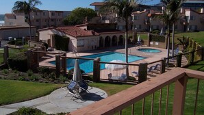 Un hotel con piscina, mobiliario exterior y vistas al océano.