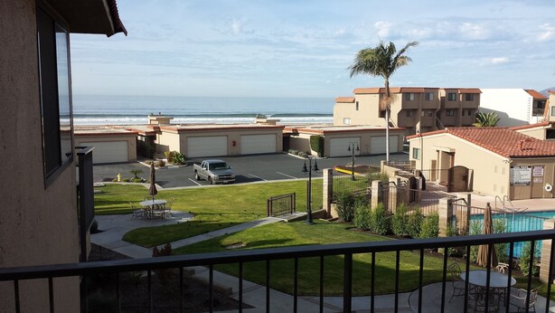 Zona residencial con vista al océano, piscina y estacionamiento.