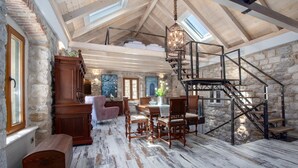 A spacious loft with exposed wooden beams, a stone wall, and a skylight. - Awesome home in Omis with house a mountain view (Omis)