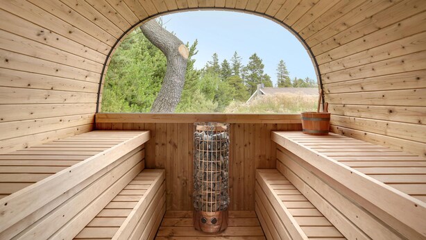 Eine Sauna mit Holzbänken und einem großen Bogenfenster.