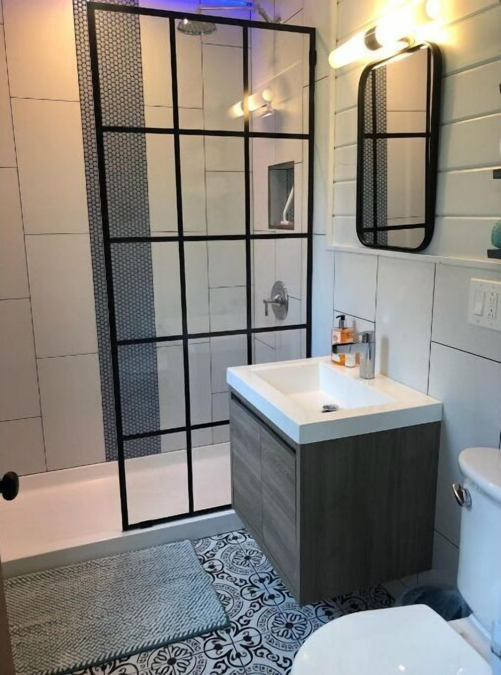 A modern bathroom with a shower enclosure, a vanity with a sink, and a toilet.