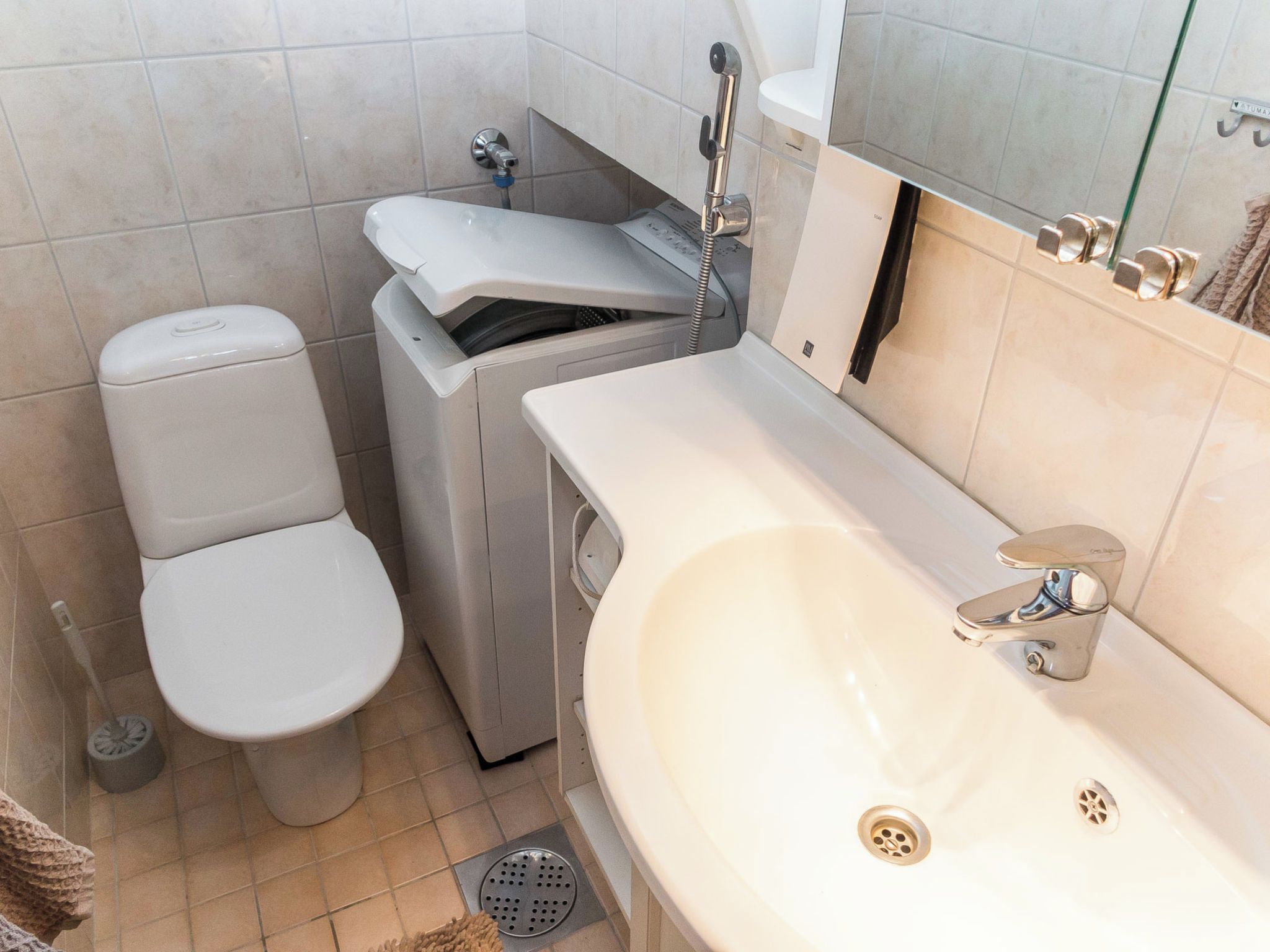 Ein Badezimmer mit Toilette, Waschmaschine und Waschbecken.