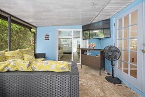 Una habitación con una cama, un ventilador y un televisor.