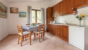 A kitchen with wooden cabinets, a dishwasher, and a dining table with chairs.