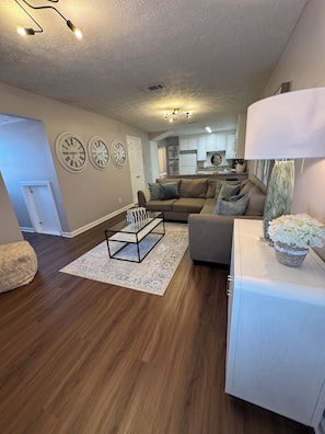 A modern living room with a sofa, a glass coffee table, and a decorative lamp.