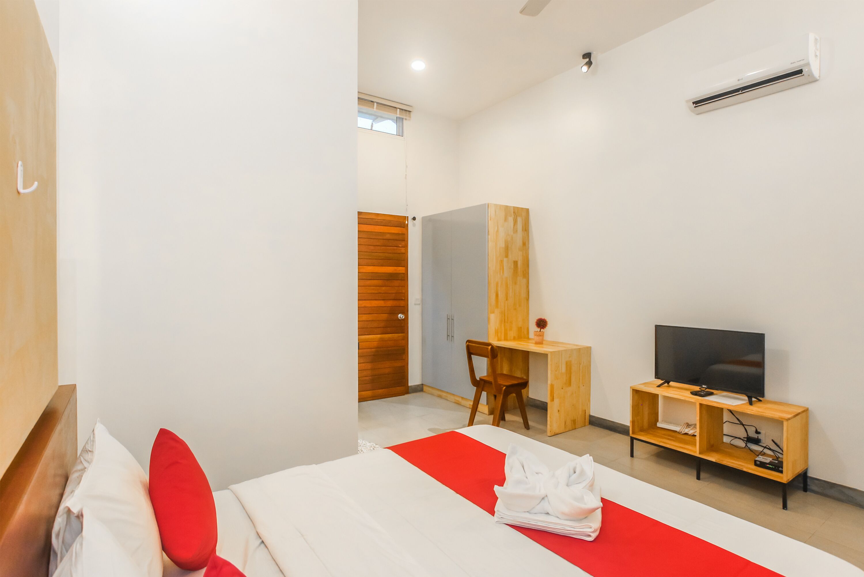 Une chambre d’hôtel moderne équipée d’un lit, d’un bureau, d’une télévision et d’une armoire.