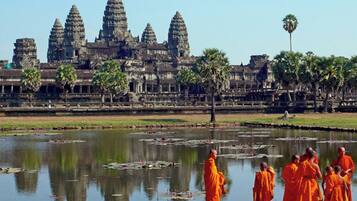 A temple complex with multiple towers and a reflection in the water.
