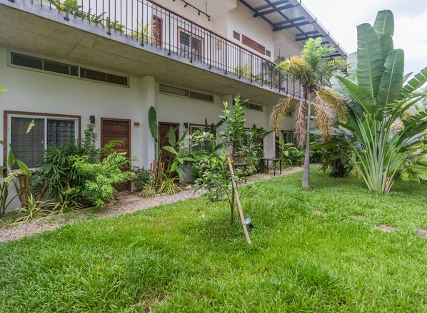 A two-story building with a balcony, surrounded by lush greenery and various plants. - Phan NaTa Apartment (Siem Reap)