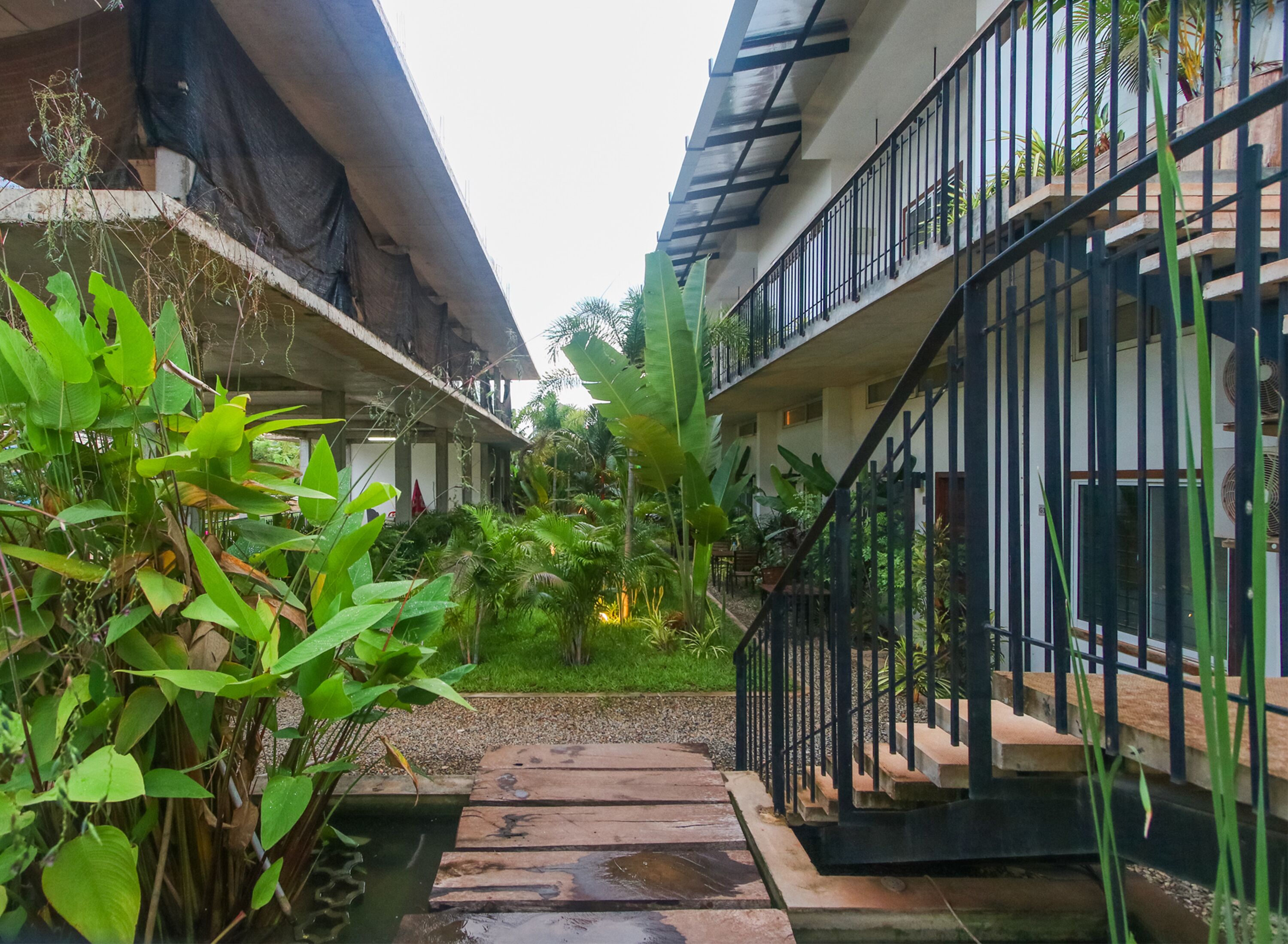A courtyard with a wooden pathway leading to a staircase.