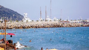 A coastal marina with yachts docked, a rocky breakwater, and people swimming in the water. - Pet friendly apartment in Imperia with WiFi (Imperia)