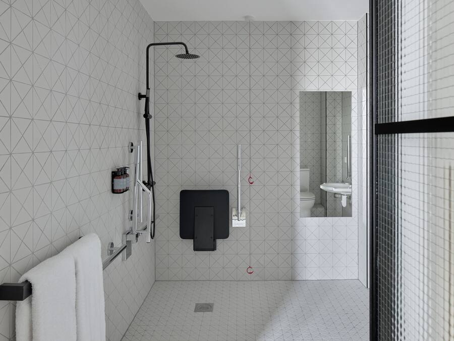 Ein modernes Badezimmer mit Dusche, Handtuchhalter und Spiegel.
