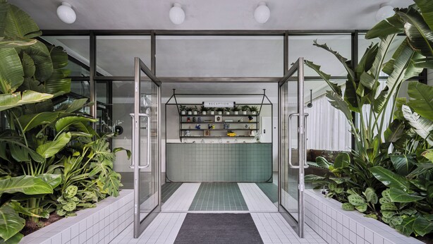A reception area with a tiled floor, a reception desk, and shelves with various items. - Staycity London Dalston (London)