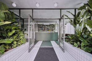 A reception area with a tiled floor, a reception desk, and shelves with various items. - Staycity London Dalston (London)