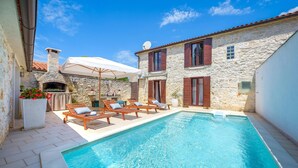 A stone building with a swimming pool, outdoor seating, and a stone oven. - Cozy home in Bale with sauna (Bale)