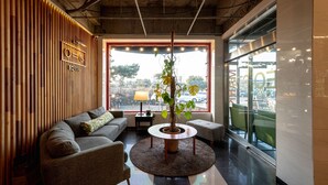 Een modern interieur met een bank, een ronde tafel en een potplant.