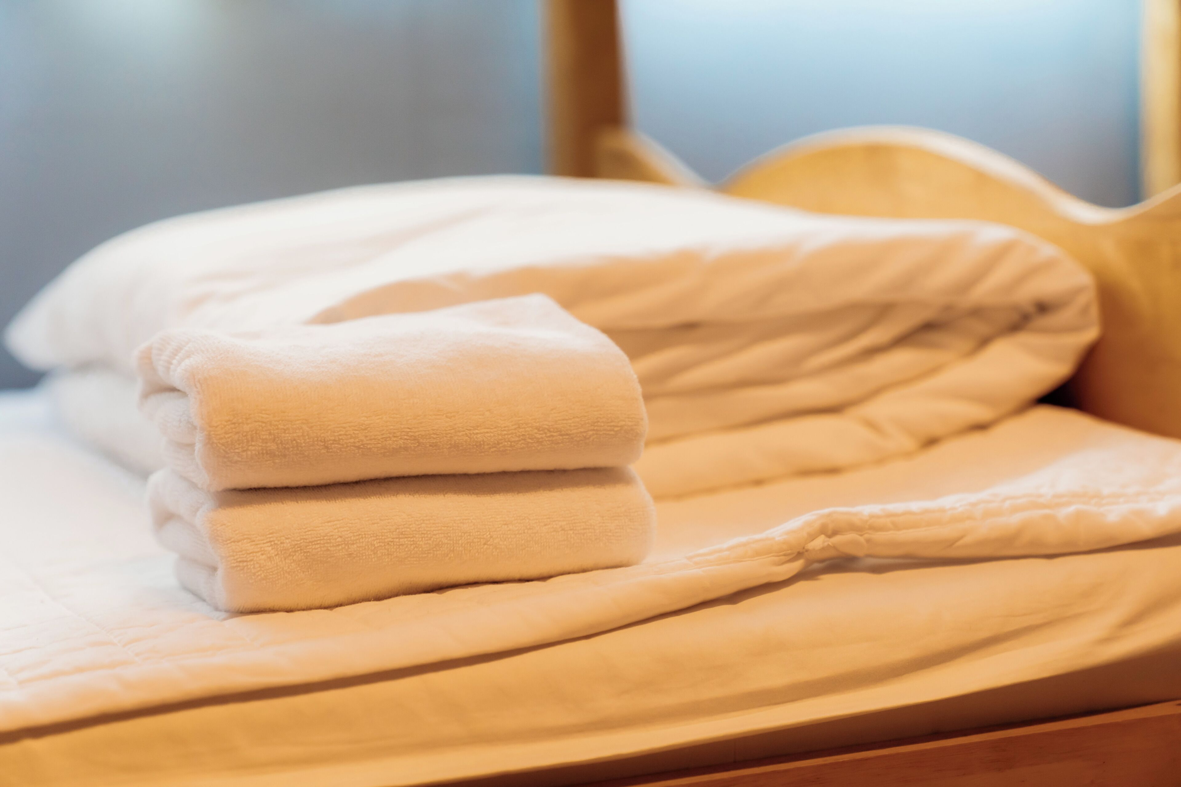 A neatly made bed with a folded blanket and pillows.