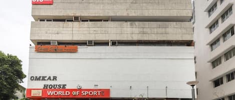 A building with a sign for OYO Hotel A1 and OMKAR HOUSE WORLD OF SPORTS.