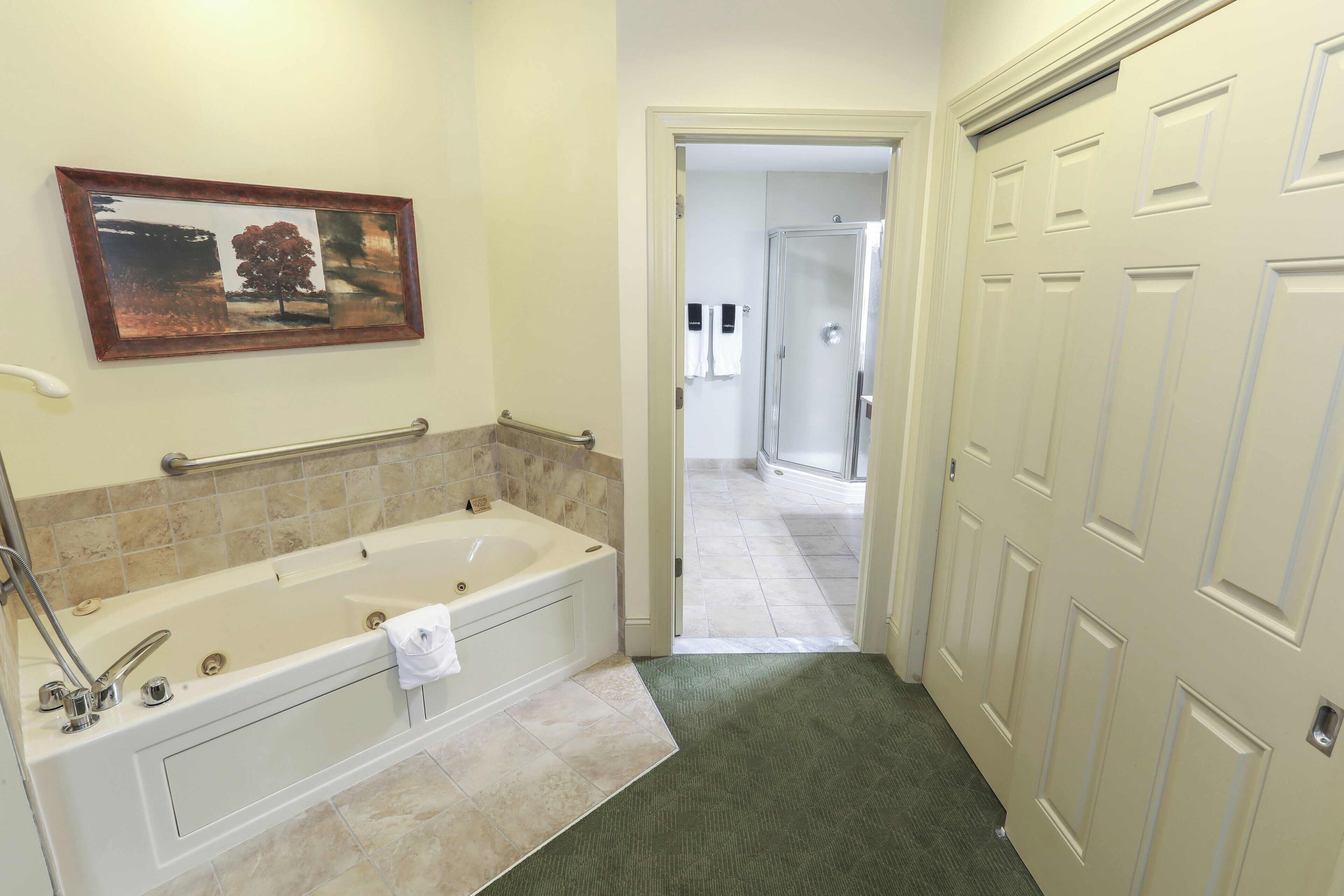 A bathroom with a bathtub, a towel rack, and a framed picture on the wall.